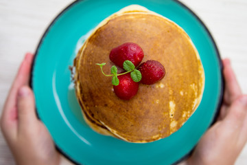 Close up breakfast pancakes with strawberries and mint