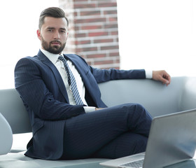 Portrait of a successful businessman sitting in the office lobby.