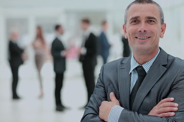 Happy mature business man looking at camera with satisfaction at office
