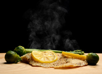 Hake white fish fillet with green asparagus brussel sprouts and lemon 