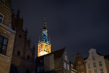 View of the Main Town Hall's lit tower and other old buildings in the Main Town (Old Town) in Gdansk, Poland, in the evening. 