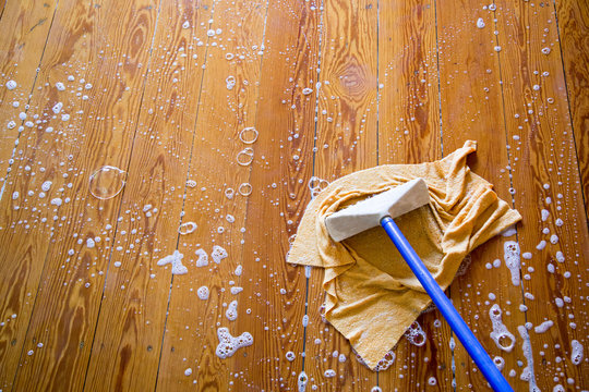 Holzfussboden mit Lappen und Schrubber 