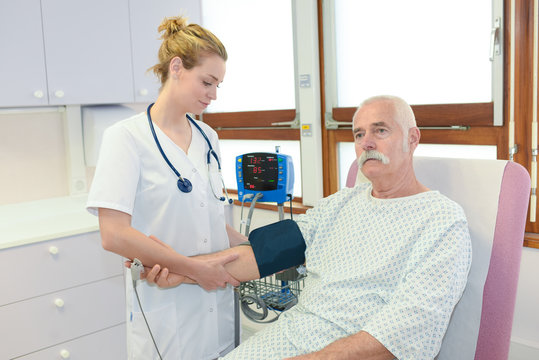 doctor measuring blood pressure of male senior patient