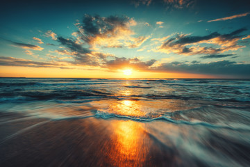 Fototapeta Piękny wschód słońca nad morzem z rozmytymi falami obraz