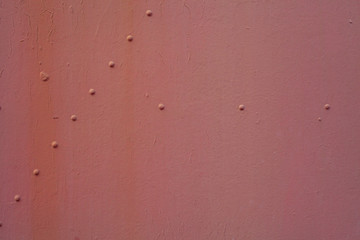 Painted metal surface. Metal painted in red. Iron plates fastened by rivets between