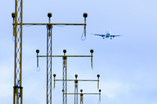 Aeroplane flying over runway landing lights at an airport