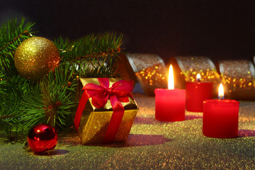 Holiday decoration with gift boxes, christmas candles, tree and colorful christmas balls. Selective focus.