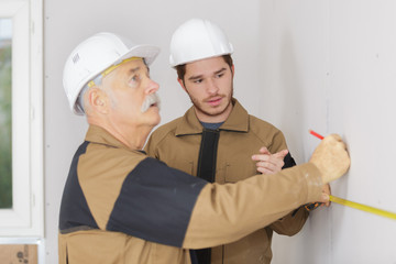 builders drawing line on wall