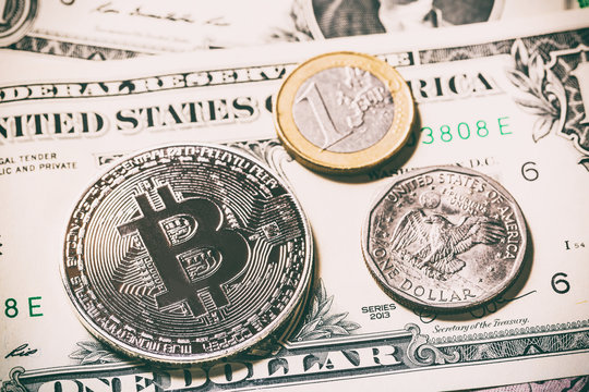 Cryptocurrency bitcoin coin near one dollar coin and one euro coin on dollar banknote. Symbol of crypto currency - electronic virtual money for web banking and international network payment