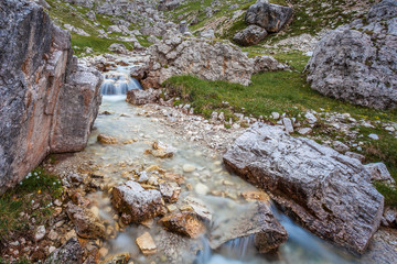 Stream with small waterfall flowing in the middle of giant boulders, Travenanzes Valley, Dolomites, Italy