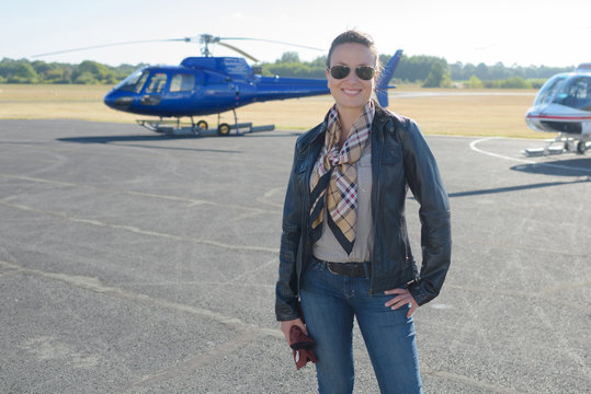 woman in the tarmac with chopper at the background