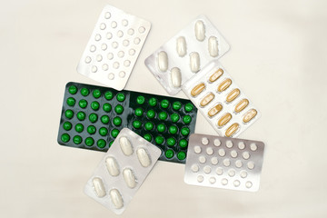 Different kinds of tablets in blasters on a light background