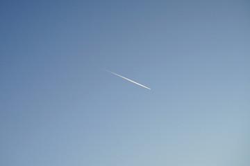 trail of white smoke from the airplane on blue sky