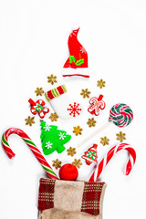 Christmas background with a sock from which scattered gifts, candy, New Year decorations toys on a white background. The concept of advertising, shopping, discounts and gifts for the winter holidays