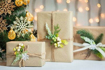 A Christmas tree decorated snowflakes and a garland with gift box on the background of a bokeh and white boards. Merry Christmas, ideas for postcards for winter holidays