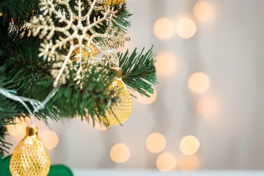 A Christmas tree decorated with snowflakes and a garland on the background of a bokeh and white boards. Merry Christmas, ideas for postcards for winter holidays