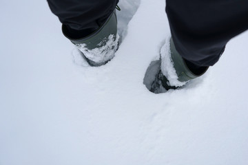 Top view of feet in boots in the snow.