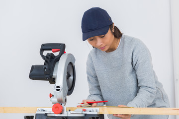 women worker using saw machine to make furniture