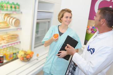 nurse getting orange out of the fridge