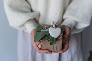 Geschenk wird von Frau schön verpackt und in Händen gehalten