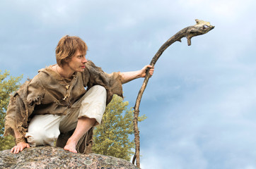 portrait of a man in medieval style on a rock with a stick