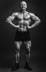 Fototapeta na wymiar Athlete in front lat spread pose. Bodybuilder showing muscles on studio background