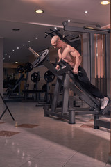 Fototapeta na wymiar one young bodybuilder, exercise equipment, chest arm, gym indoors. full lenght shot.