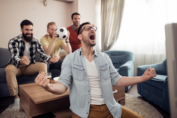 Group of friends watching football game together