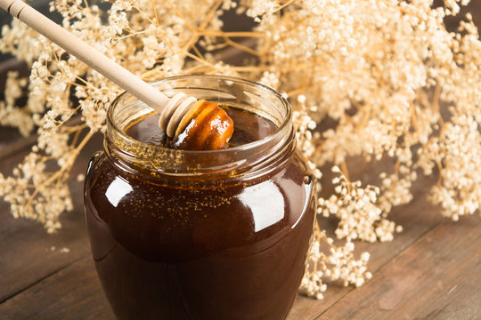 Closeup of dark honey with spoon