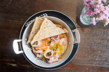 Breakfast,pan-fried egg, pan omelet with seafood topping and toast