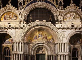 Fototapeta na wymiar Facade view of Saint Mark's Basilica (San Marco) at night in Venice / Italy. Iconic cathedral with a cavernous gilded interior, myriad mosaics & an on-site museum.