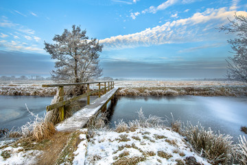 Footbridge over Frozen canal in  the province of Drenthe