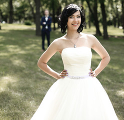 fun bride standing in a Park on a summer day