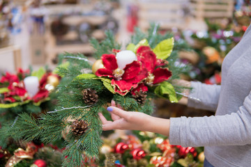 Closeup view of customer choosing Christmas decorations. Various choice of New Year's wreath with decorations