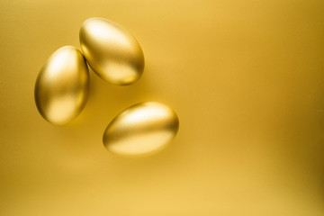 Financial success. Golden Egg on golden background