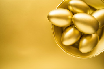 Financial success. Golden Egg in Golden Plate on golden background