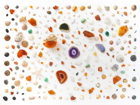 A creative pattern of shells, unprocessed pieces of amber, natural stones, starfish. Composition of natural materials, flat lay, top view. Summer, sea concept. Marine background, stone texture.