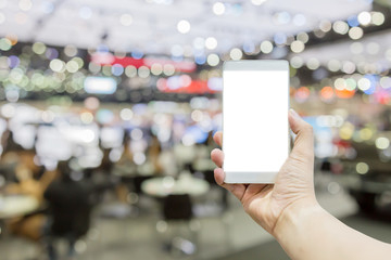hand hold white screen smartphone on blur image background of expo event
