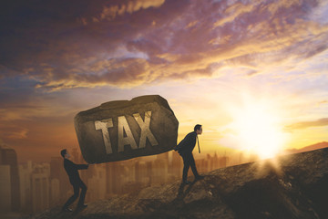 Two business people carrying tax word