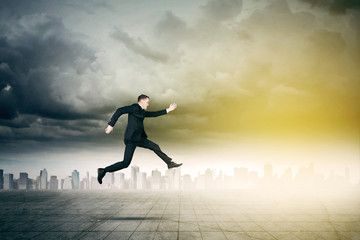 Businessman jumping with skyscraper background