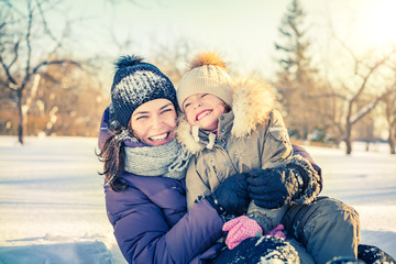 Obraz premium Little girl and her mother playing outdoors at sunny winter day