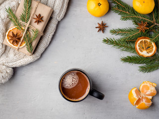Obraz na płótnie Canvas Winter hot chocolate drink in a Cup on a gray concrete background tangerines festive decorations Copy space
