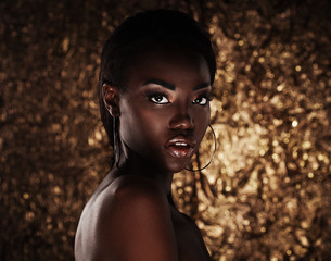 portrait of sensual young african woman against golden background