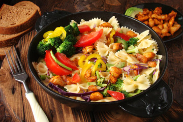 Farfalle pasta with slices of grilled chicken, sweet peppers, avocado, cabbage, broccoli, tomatoes and red cabbage