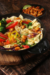 Farfalle pasta with slices of grilled chicken, sweet peppers, avocado, cabbage, broccoli, tomatoes and red cabbage