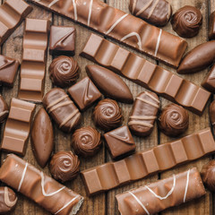 Background of chocolates, bars and sweets, free space for text, close up