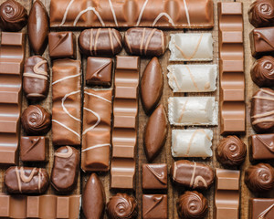 Background of chocolates, bars and sweets, free space for text, close up