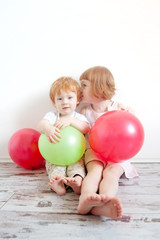 Fototapeta na wymiar Red-haired brother and sister playing with balloons