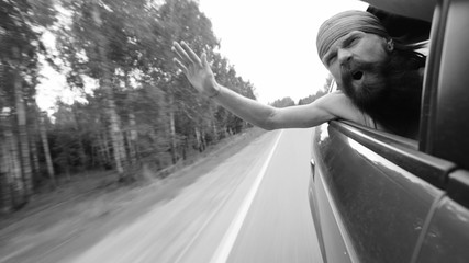 Happy young tourist man have fun and joy in window of car while travelling