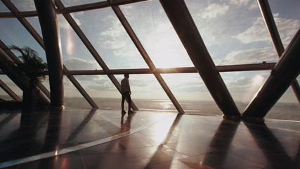 Silhouette of businessman stand near window in modern office building